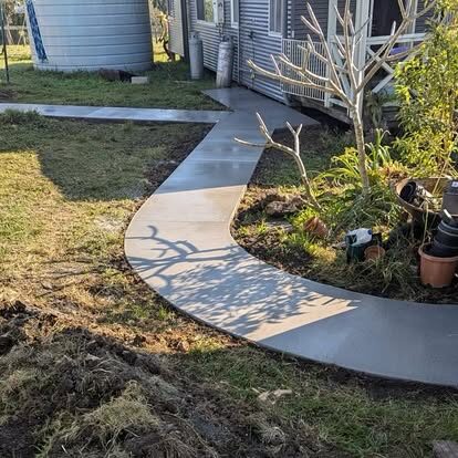 A curved concrete garden path winding through a yard