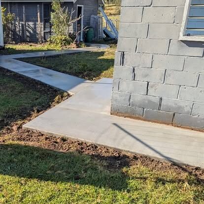A concrete path running beside a besser-block retaining wall